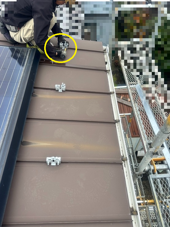 まずはじめに、立平葺き屋根の凸部分に、雪止めアングルの金具を挟んでナットで締めます。