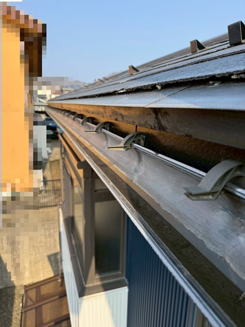 雨どいの金具が折れて傾いています